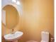 A half bathroom with a pedestal sink, lighting and toilet with neutral colored walls at 11242 Almador Vista Ct, Las Vegas, NV 89135
