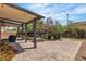 Serene backyard featuring a covered patio, lush greenery, a stone fountain, and brick-paved ground at 1161 Sax Fifth Ave, Henderson, NV 89052