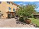 Picturesque backyard with a covered patio, lush landscaping, a stone fountain, and a brick-paved patio at 1161 Sax Fifth Ave, Henderson, NV 89052