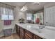Bright bathroom with a double sink vanity, large mirror, decorative window treatments and shower at 1161 Sax Fifth Ave, Henderson, NV 89052
