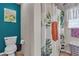 Modern bathroom featuring a toilet, shower with a colorful curtain, and stylish decor and pops of color at 1161 Sax Fifth Ave, Henderson, NV 89052