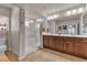 Bright bathroom with a glass walk-in shower, dual sinks and dark wood cabinets at 1161 Sax Fifth Ave, Henderson, NV 89052