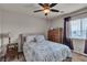 Cozy bedroom featuring a ceiling fan, comfortable bed, and a wooden dresser with natural light from the window at 1161 Sax Fifth Ave, Henderson, NV 89052