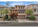 Charming stucco home featuring stone accents, manicured landscaping, and a two-car garage at 1161 Sax Fifth Ave, Henderson, NV 89052