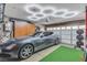 Bright and spacious garage featuring epoxy floors, custom lighting, storage cabinets, and a sporty grey sedan at 1161 Sax Fifth Ave, Henderson, NV 89052