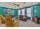 Living room with teal walls, natural light, comfortable seating, and unique artwork, creating a vibrant and welcoming space at 1161 Sax Fifth Ave, Henderson, NV 89052