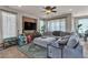 Cozy living room with a large sectional sofa, ceiling fan, and views of the backyard at 1161 Sax Fifth Ave, Henderson, NV 89052