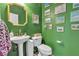 Compact powder room with green walls, a pedestal sink, a toilet, and framed wall art adding character to the space at 1161 Sax Fifth Ave, Henderson, NV 89052