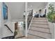 Staircase with white risers and wooden handrail with large windows at the top and bottom of the stairs at 1161 Sax Fifth Ave, Henderson, NV 89052