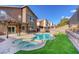 Beautiful backyard featuring a sparkling pool, spa, lush lawn, and a covered patio at 1481 Rancho Ridge Dr, Henderson, NV 89012
