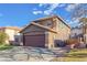 A two-story home featuring a brown facade, two-car garage, and an extended driveway at 1481 Rancho Ridge Dr, Henderson, NV 89012