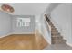 Open-concept living room with hardwood floors, staircase, and neutral walls at 1481 Rancho Ridge Dr, Henderson, NV 89012