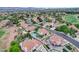 A picturesque aerial view of a neighborhood featuring tile roofs, lush landscaping, and a nearby golf course at 150 Wentworth Dr, Henderson, NV 89074