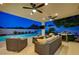 Backyard featuring a covered patio, a swimming pool, lush greenery, and outdoor seating at dusk at 150 Wentworth Dr, Henderson, NV 89074