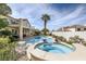 Private backyard oasis featuring a sparkling pool, hot tub, and mature palm trees at 150 Wentworth Dr, Henderson, NV 89074