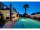 Inviting backyard oasis with a pool, covered patio, and swaying palm trees at 150 Wentworth Dr, Henderson, NV 89074