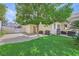 Spacious backyard with a manicured lawn, mature trees, and a covered patio equipped with a grill and seating area at 150 Wentworth Dr, Henderson, NV 89074