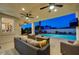 Charming backyard with a covered patio, a swimming pool, lush greenery, and outdoor seating at dusk at 150 Wentworth Dr, Henderson, NV 89074