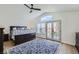 Primary bedroom featuring a high ceiling, ceiling fan, and balcony access with neighborhood views at 150 Wentworth Dr, Henderson, NV 89074