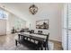 Open-concept dining area features a modern light fixture, a long wooden table, and plantation shutters at 150 Wentworth Dr, Henderson, NV 89074