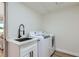 Well-lit laundry room featuring a sink, a white countertop, and a new washer and dryer at 150 Wentworth Dr, Henderson, NV 89074