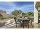 Cozy outdoor dining area with a round table, comfortable chairs, and a lush garden backdrop, ideal for al fresco meals at 150 Wentworth Dr, Henderson, NV 89074