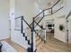 Elegant staircase with neutral walls, wood and black handrails, and an open floorplan at 150 Wentworth Dr, Henderson, NV 89074