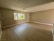 Bright living room featuring a large window and hardwood floors at 173 Greenbriar Townhouse Way, Las Vegas, NV 89121