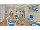 Open-concept dining room with a glass table, comfortable blue chairs, and stylish décor at 1848 Indian Bend Dr, Henderson, NV 89074