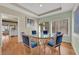 Elegant dining room with glass table, blue upholstered chairs, and natural light at 1848 Indian Bend Dr, Henderson, NV 89074