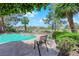 Beautiful backyard pool with lush landscaping, serene seating, and a view of mature trees at 1848 Indian Bend Dr, Henderson, NV 89074