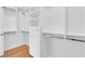 Walk-in closet features built-in shelving, drawers, and rods for ample storage with a wood floor at 1848 Indian Bend Dr, Henderson, NV 89074