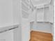 Walk-in closet features built-in shelving, drawers, and rods for ample storage with wood floor at 1848 Indian Bend Dr, Henderson, NV 89074