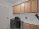 Functional laundry room with washer, dryer, sink, and plenty of cabinet space for storage at 1912 Summer Pine Ct # 103, Las Vegas, NV 89134