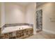 Bathroom showcasing a relaxing soaking tub and tiled glass shower with neutral color palette at 200 Hoover Ave # 912, Las Vegas, NV 89101