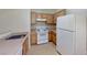 A functional kitchen featuring white appliances and wooden cabinetry, ready for meal preparation at 2141 Hussium Hills St # 102, Las Vegas, NV 89108