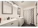 Well-lit bathroom with dual sinks, modern fixtures, and a shower with a patterned curtain at 2714 Cottonwillow St, Las Vegas, NV 89135