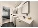 Bright bathroom featuring double sinks with gray cabinets, modern lighting, and wood-look floors at 2714 Cottonwillow St, Las Vegas, NV 89135