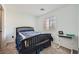 Comfortable bedroom with a dark wood bed frame, a desk, and a window with blinds at 2714 Cottonwillow St, Las Vegas, NV 89135
