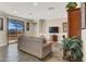 Open living room with stone floors, neutral colors, and sliding glass doors to patio at 31 Via Mantova # 1, Henderson, NV 89011