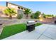 Backyard featuring a grill, palm trees, decorative rock, pavers, and artifical turf for low maintenance and outdoor living at 334 Shimmering Moon St, Henderson, NV 89015