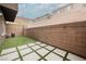 Backyard with artificial turf, decorative concrete tiles, and a brick privacy wall at 376 Yellow Finch Ln, Henderson, NV 89012