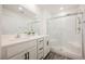 A modern bathroom featuring double sinks, wood look flooring, and a glass-enclosed shower at 376 Yellow Finch Ln, Henderson, NV 89012