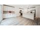 Bright kitchen boasts white cabinets, stainless steel appliances, tile backsplash, wood-look flooring and a large island at 376 Yellow Finch Ln, Henderson, NV 89012