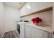 Well-lit laundry room featuring white cabinets, counter, and modern machines at 376 Yellow Finch Ln, Henderson, NV 89012