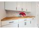 Bright laundry room features white cabinetry, wood countertop, and stylish mosaic tile backsplash at 376 Yellow Finch Ln, Henderson, NV 89012