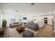 Open-concept living room with stylish gray sofas, wood flooring, and a view into the modern kitchen at 376 Yellow Finch Ln, Henderson, NV 89012