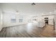 Bright, open-concept living room and kitchen with wood-look tile floors and modern appliances at 376 Yellow Finch Ln, Henderson, NV 89012