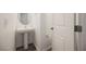 Compact powder room features a pedestal sink, round mirror and modern fixtures at 376 Yellow Finch Ln, Henderson, NV 89012
