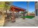 An outdoor cabana with seating sits on a patio surrounded by artifical grass and landscape at 3794 Cape Royal St, Las Vegas, NV 89147
